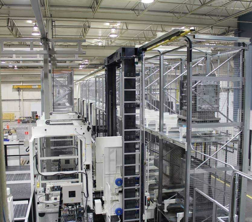 A large industrial robotic automation system by Centra Industries, with metal frameworks and machinery inside a spacious factory, featuring safety cages and overhead lighting.