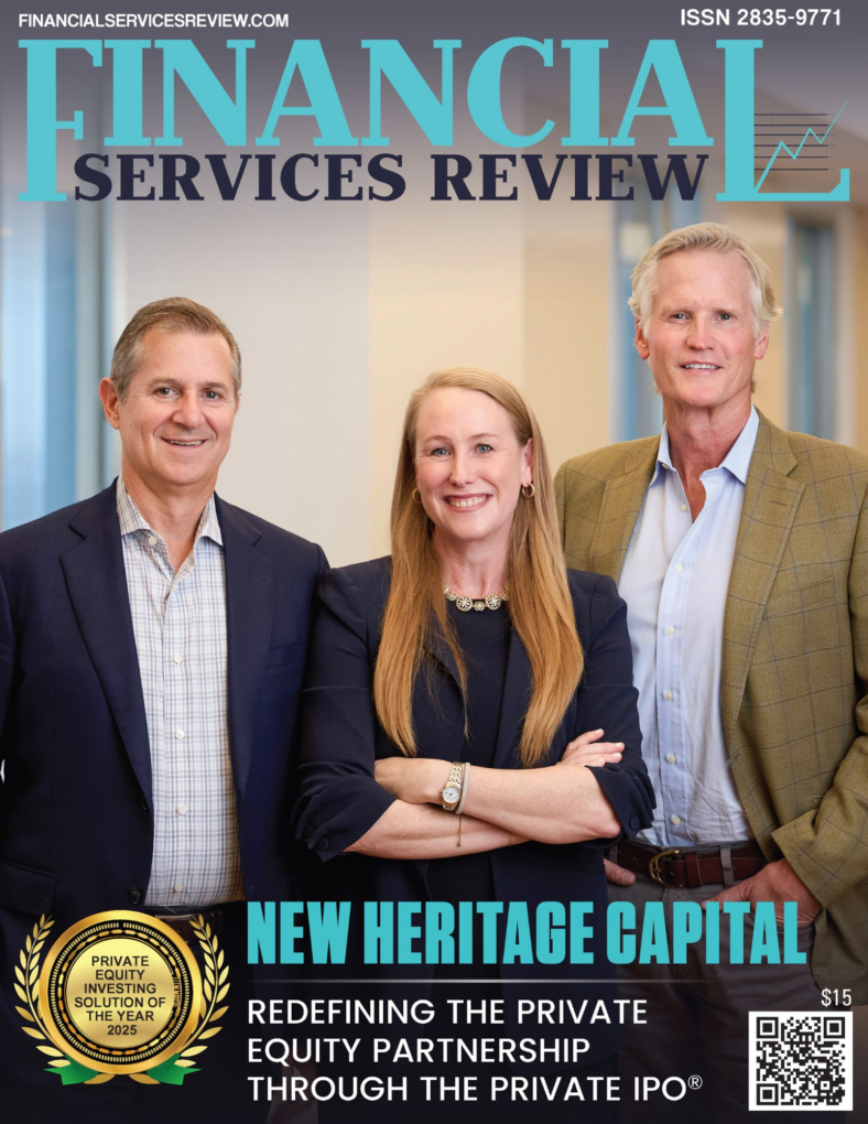 Three professionally dressed people, two men and one woman, stand smiling in an office setting on the cover of Financial Services Review magazine. Headline reads: "New Heritage Capital: Redefining the Private Equity Partnership with innovative investing solutions.