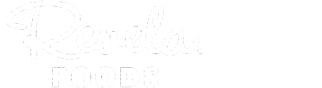 White logo on a light background displaying the words “Revela FOODS” in a mix of script (Revela) and bold uppercase (FOODS) font.