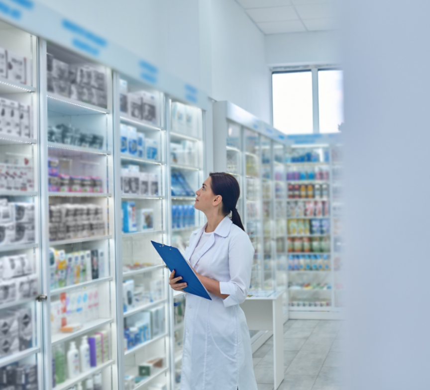 A pharmacist in a white coat holds a blue clipboard while examining shelves filled with various medical products and brilliant gifts in a brightly lit pharmacy.