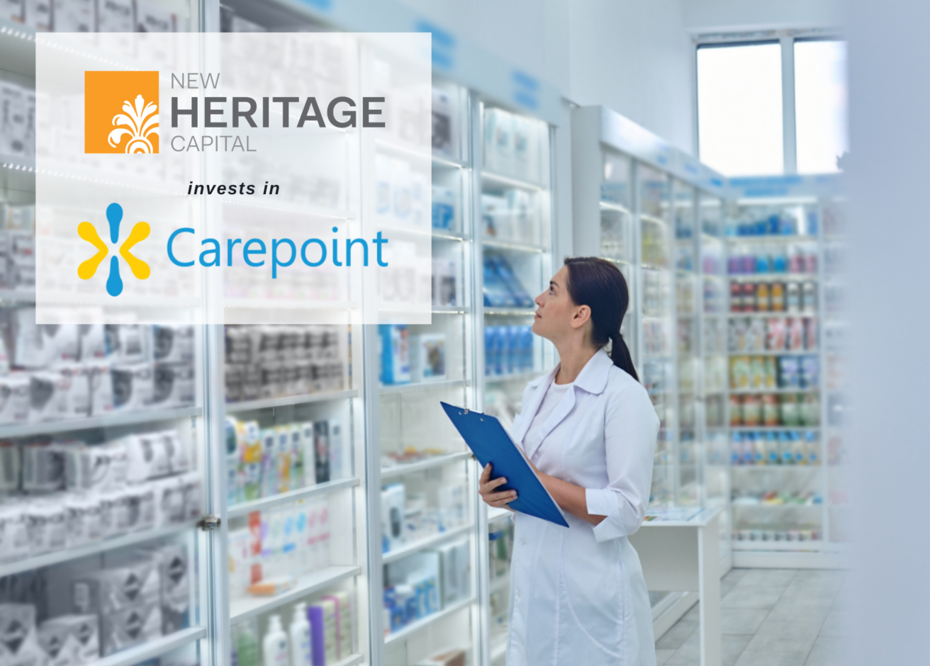 A woman in a white coat holds a blue clipboard, standing in a pharmacy aisle. Overlaid text reads, “New Heritage Capital invests in Carepoint,” highlighting their partnership. Shelves with various products fill the background.